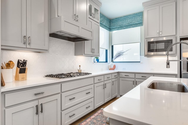 kitchen featuring backsplash, stainless steel appliances, and sink