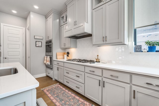 kitchen with sink, tasteful backsplash, stainless steel appliances, and dark wood-type flooring