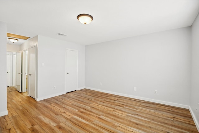 unfurnished room with light wood-type flooring