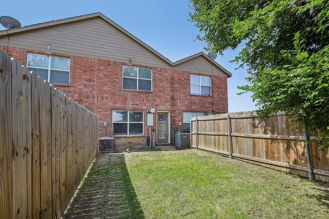 back of house with central AC and a lawn