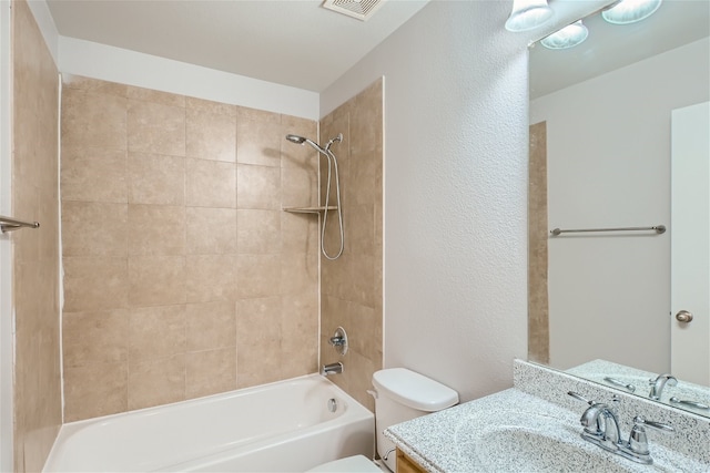 full bathroom with vanity, tiled shower / bath, and toilet