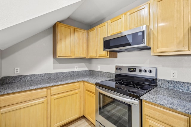 kitchen with stainless steel appliances, vaulted ceiling, and light brown cabinets