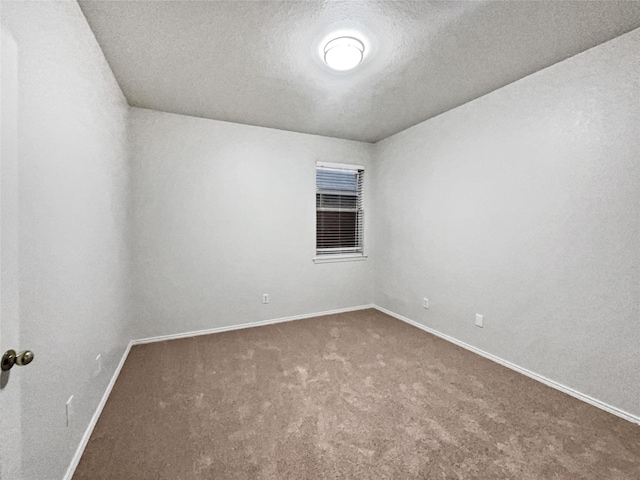 unfurnished room with carpet flooring and a textured ceiling