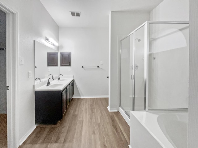 bathroom with hardwood / wood-style floors, vanity, and shower with separate bathtub