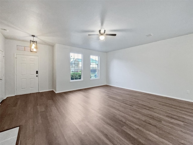 unfurnished living room with dark hardwood / wood-style flooring and ceiling fan