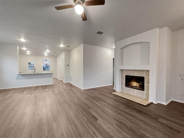 unfurnished living room featuring a fireplace, hardwood / wood-style flooring, ceiling fan, and sink