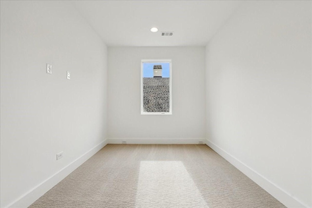 spare room featuring light colored carpet