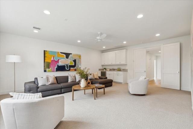 carpeted living room featuring ceiling fan