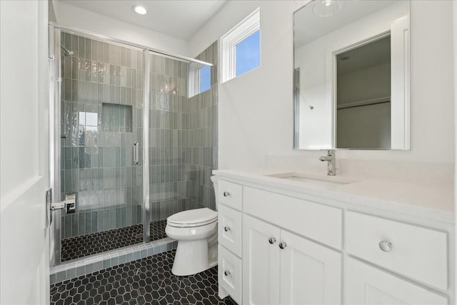 bathroom featuring vanity, an enclosed shower, and toilet