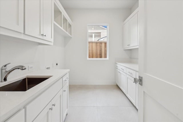 laundry room with cabinets, hookup for a washing machine, hookup for an electric dryer, sink, and light tile patterned floors