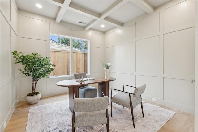 dining space with beam ceiling, light wood-type flooring, and coffered ceiling