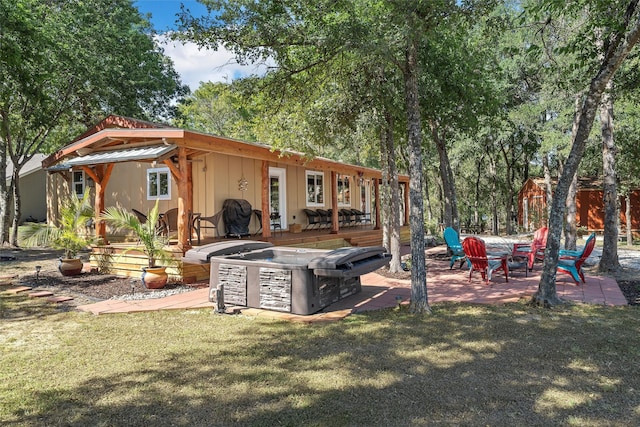 rear view of house featuring a yard, an outdoor fire pit, and a patio