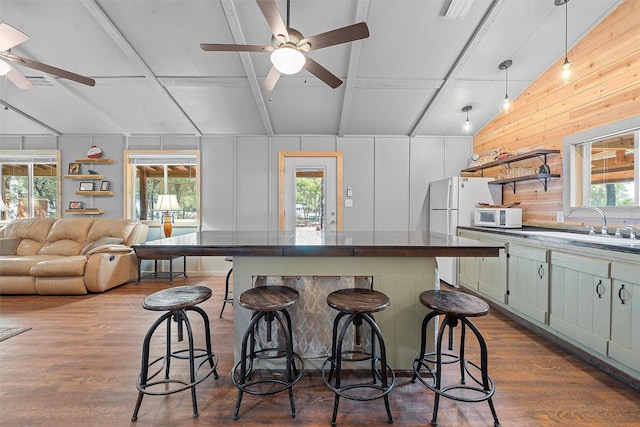 kitchen featuring green cabinets, plenty of natural light, dark hardwood / wood-style floors, and decorative light fixtures