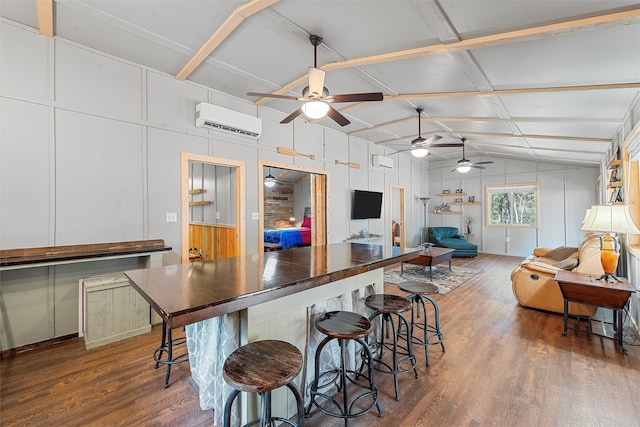 kitchen with dark hardwood / wood-style flooring, vaulted ceiling, a wall mounted AC, ceiling fan, and white cabinetry