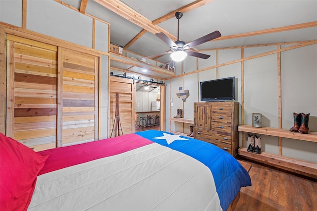 bedroom with ceiling fan, dark wood-type flooring, and vaulted ceiling