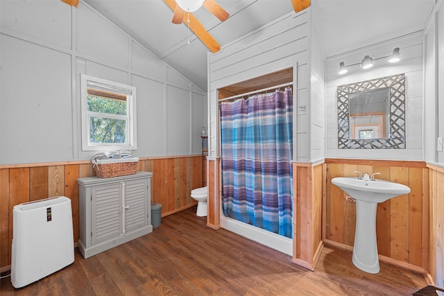 bathroom featuring ceiling fan, a shower with curtain, hardwood / wood-style floors, vaulted ceiling, and toilet