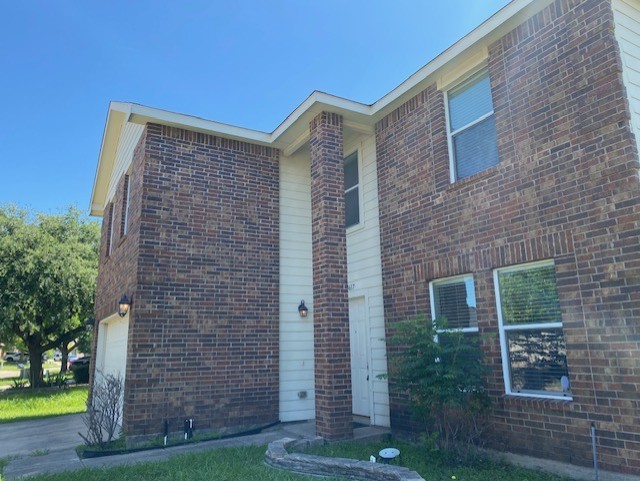 view of front of home with an attached garage and brick siding