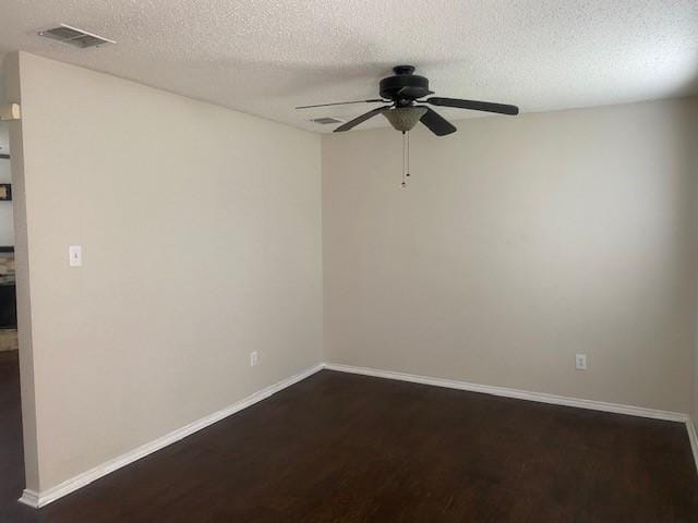 empty room featuring dark hardwood / wood-style flooring, a textured ceiling, and ceiling fan