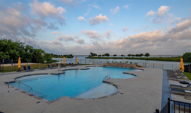 view of swimming pool featuring a patio area and a water view