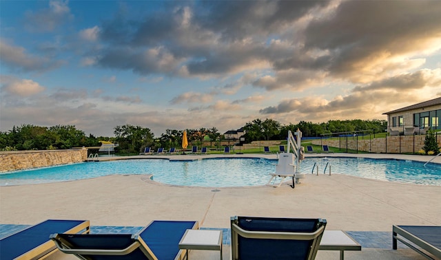 pool at dusk with a patio