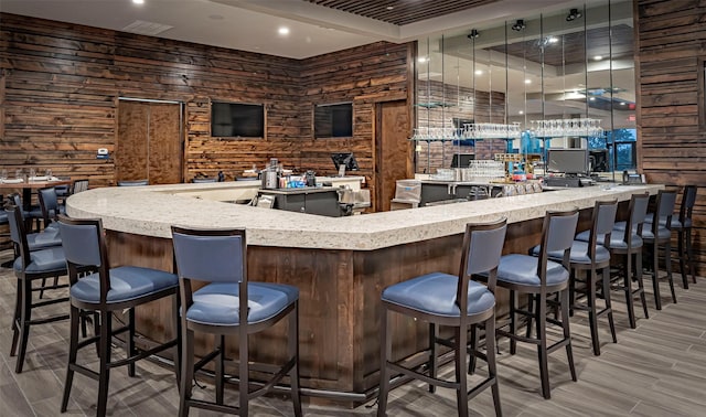 bar featuring hardwood / wood-style floors and wood walls