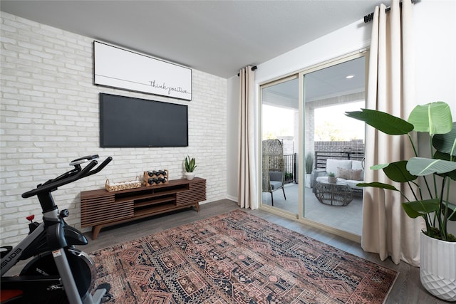 interior space with brick wall and hardwood / wood-style flooring