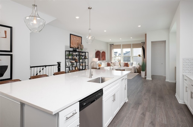 kitchen with pendant lighting, a kitchen island with sink, and sink