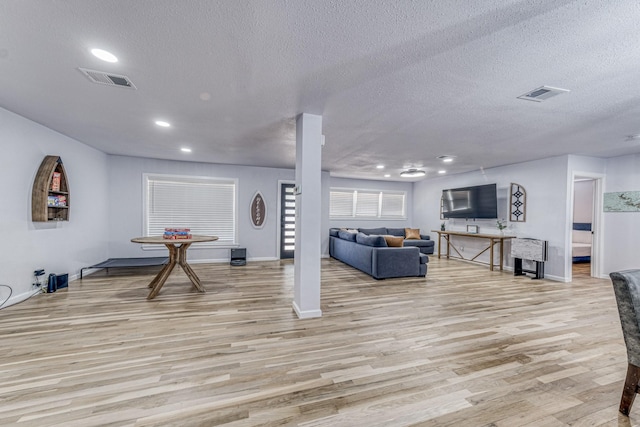 interior space with a textured ceiling and light hardwood / wood-style floors