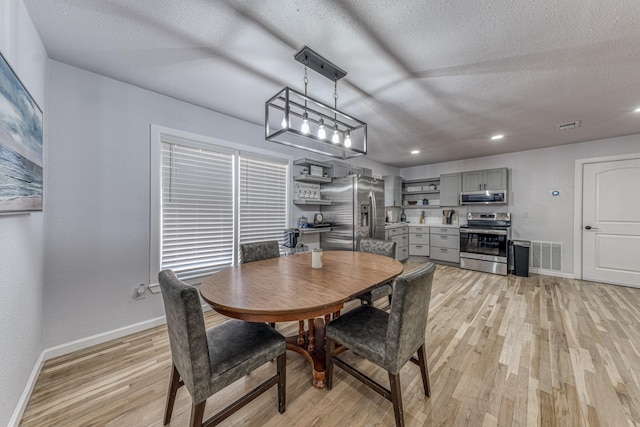 dining space featuring a textured ceiling and light hardwood / wood-style flooring