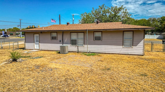 rear view of property with a yard and central AC