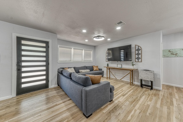 living room featuring light hardwood / wood-style floors and a textured ceiling