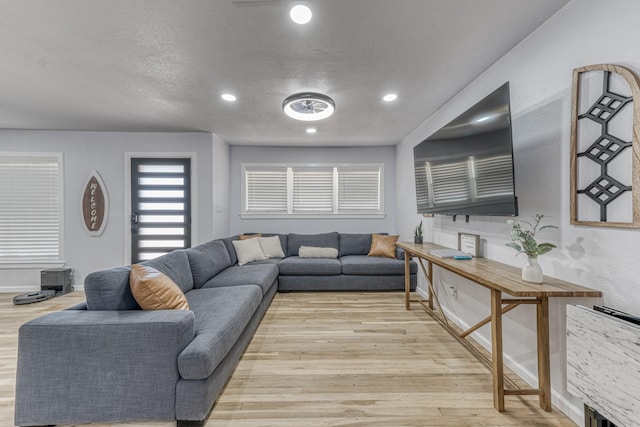 living room featuring light hardwood / wood-style floors and a textured ceiling