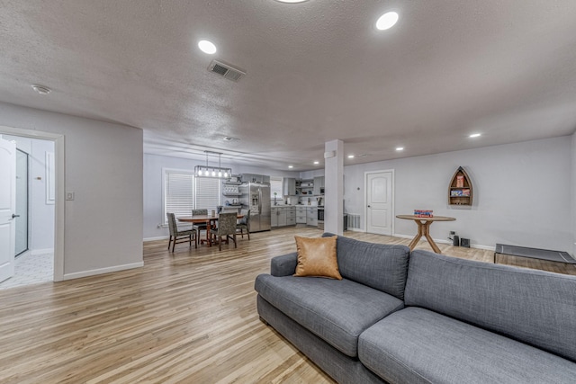 living room featuring a textured ceiling and light hardwood / wood-style flooring