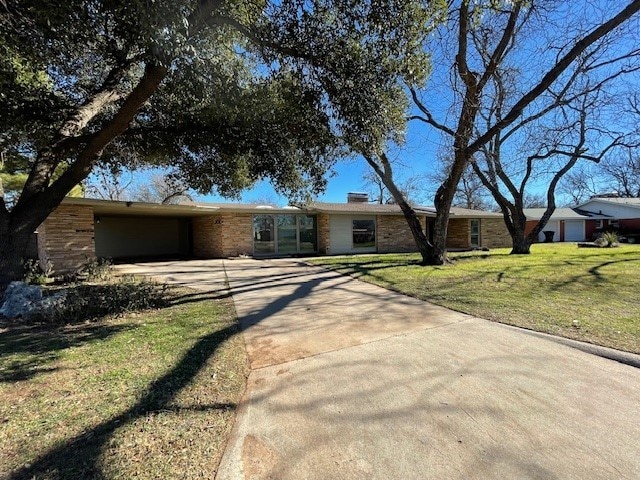 single story home featuring a front lawn and a carport