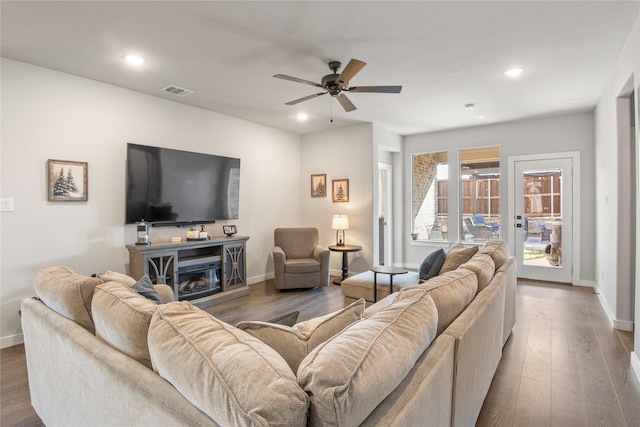 living room featuring ceiling fan, wood-type flooring, and a fireplace