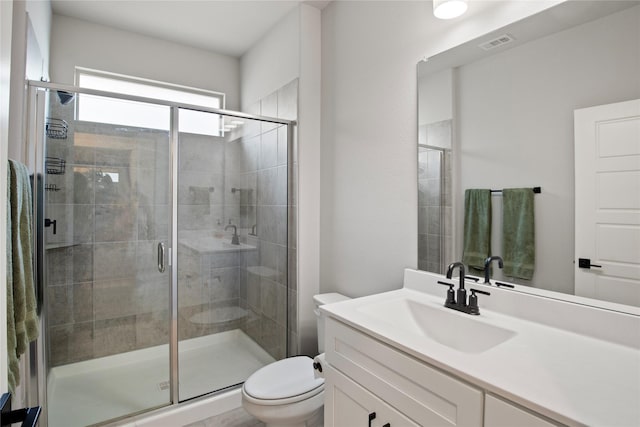 bathroom featuring walk in shower, vanity, and toilet