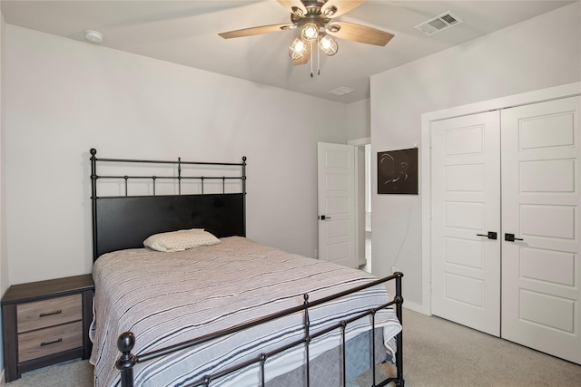 carpeted bedroom featuring ceiling fan and a closet