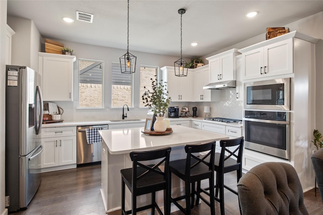 kitchen featuring stainless steel appliances, white cabinets, and tasteful backsplash