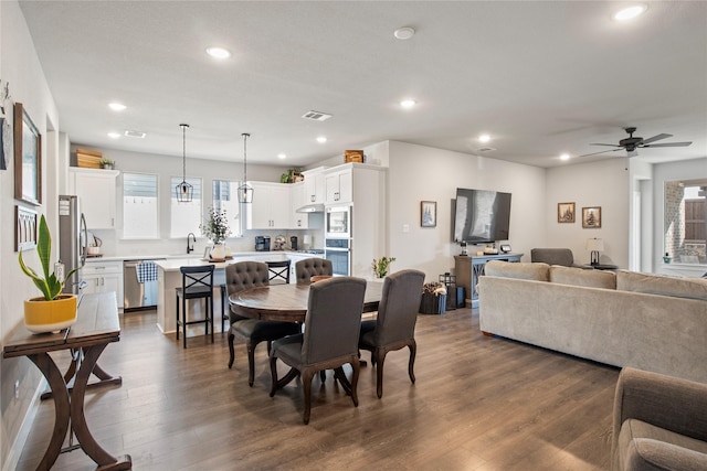 dining room with ceiling fan, dark wood-type flooring, and sink