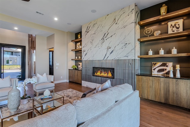 living room featuring a fireplace, dark hardwood / wood-style flooring, and built in features