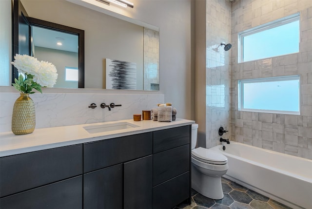 full bathroom featuring toilet, vanity, and tiled shower / bath