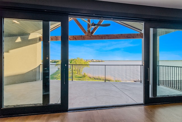 entryway with hardwood / wood-style flooring, vaulted ceiling, and a water view