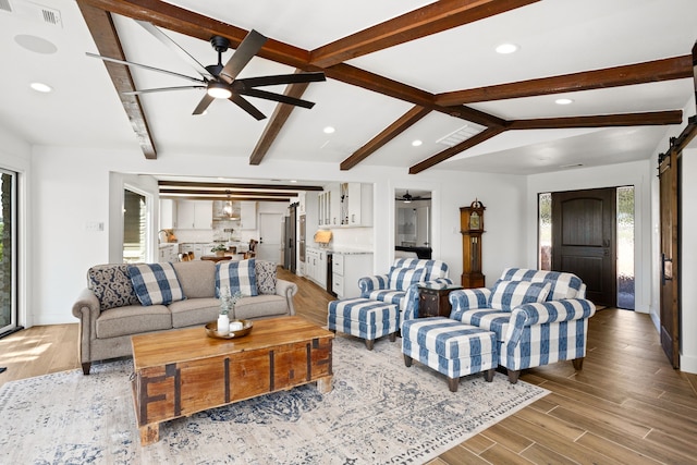 living room featuring vaulted ceiling with beams, a barn door, and ceiling fan