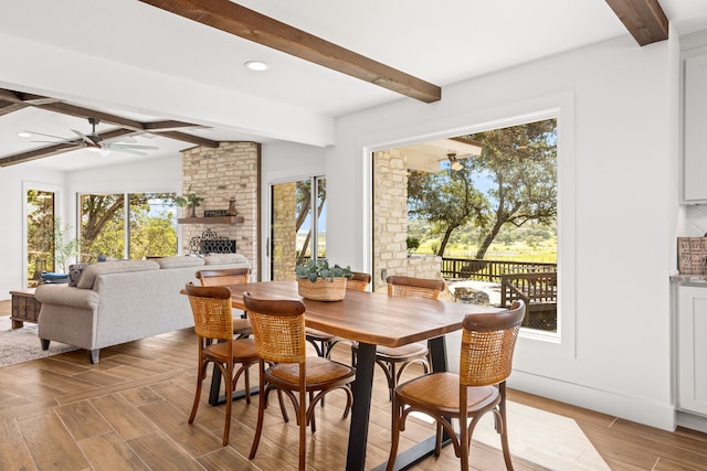 dining area featuring beamed ceiling, plenty of natural light, and ceiling fan