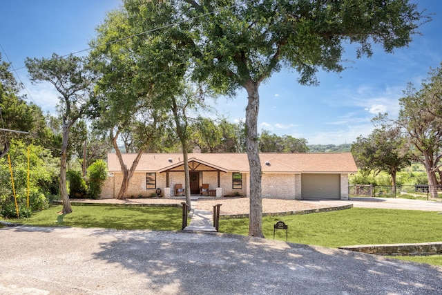 single story home with a garage and a front lawn