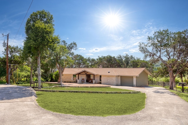 single story home with a garage and a front yard