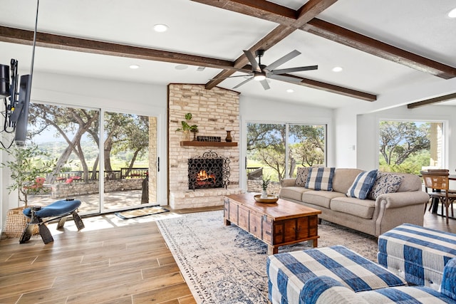 living room featuring a fireplace, vaulted ceiling with beams, and ceiling fan