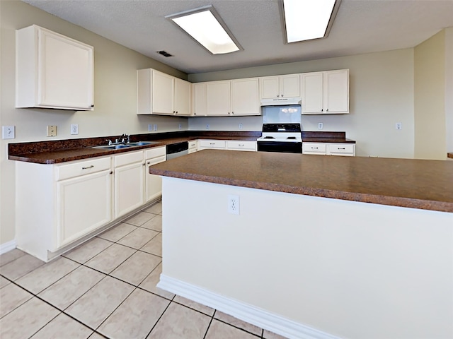 kitchen with light tile patterned floors, under cabinet range hood, electric range, a sink, and dark countertops