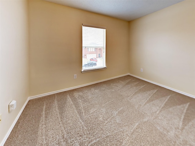 unfurnished room featuring carpet floors and baseboards