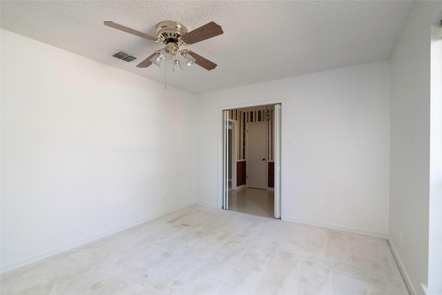 carpeted spare room with a textured ceiling and ceiling fan